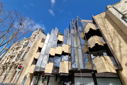 Cordistes le long d'une façade de béton et de verre d'un bâtiment contemporain