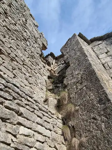 Mur de pierre en hauteur, reprise de maçonnerie en cours